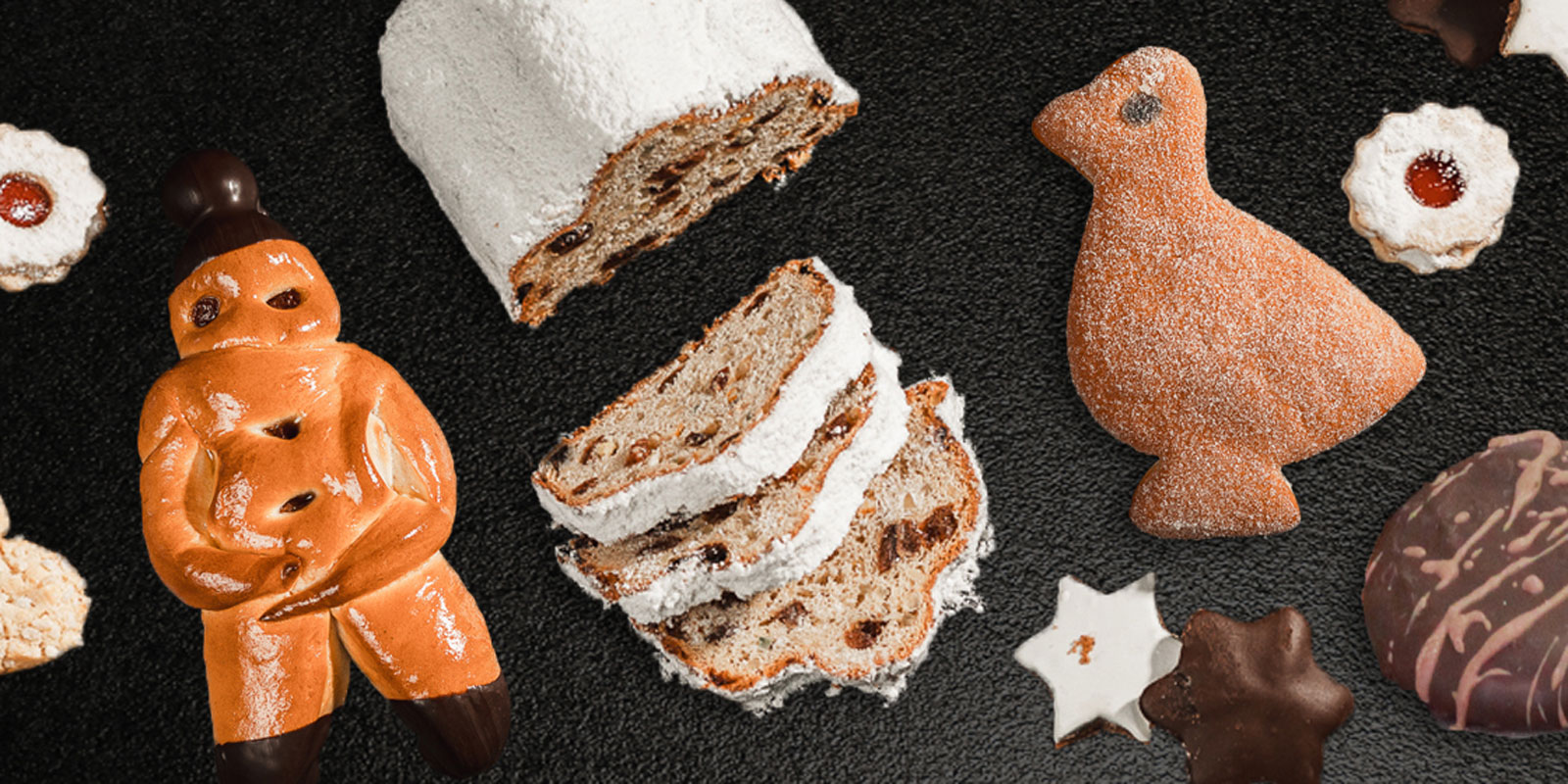 weihnachtliches Gebäck, Lebkuchen und Stollen liegen auf einem schwarzen Untergrund
